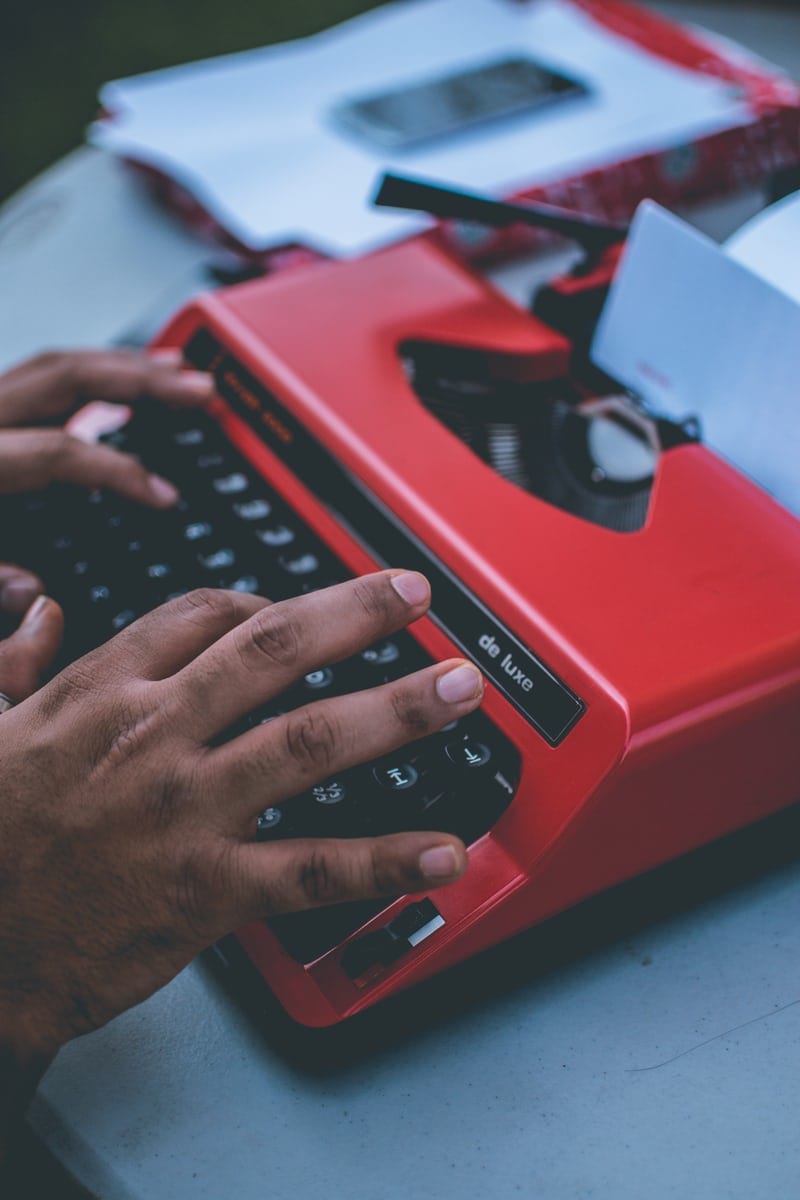 typing on old red typewriter