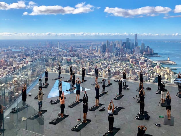 yoga group on top of building with skyline