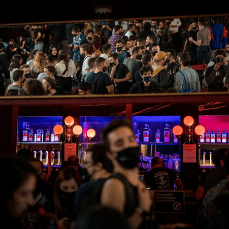 bar with large crowd wearing masks