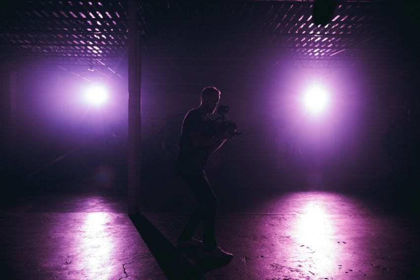 camera man filming in purple lights