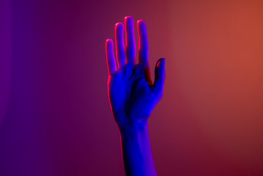 hand raised on colored background