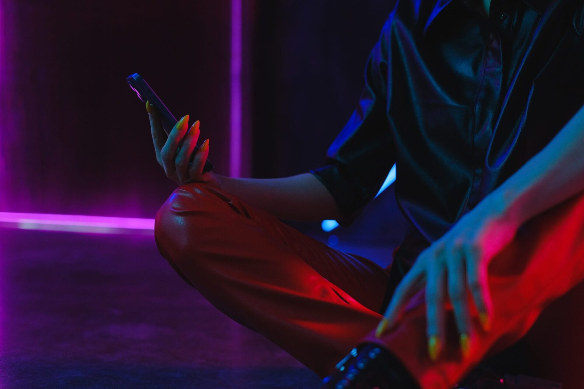 person sitting on floor looking at phone